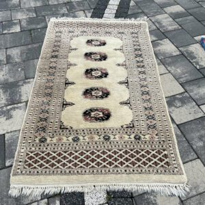 Elegancki pakistański dywan gabinetowy Bukhara Premium – 138 x 78 cm, 100% naturalna wełna, rozświetlające kremowe tło, rytmiczny motyw medalionów Gül #129